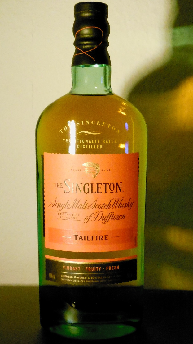 Tiefe bernsteinfarbene Flasche Singleton of Dufftown Tailfire Single Malt Scotch Whisky mit einem schwarzen Etikett, das ein Löwen- und Schlosswappen zeigt.