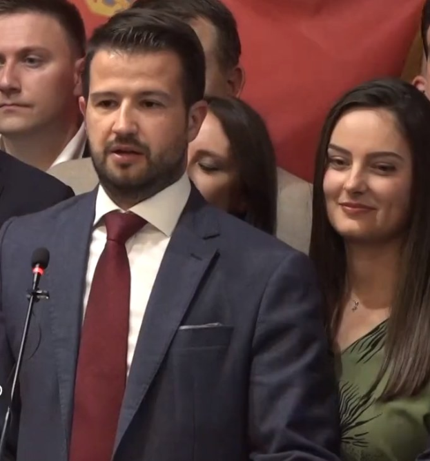 Ein Mann im Anzug spricht vor einem Publikum an einem Rednerpult mit Mikrofon, wahrscheinlich über ein von der Regierung beschlossenes Verbot von Social Media.