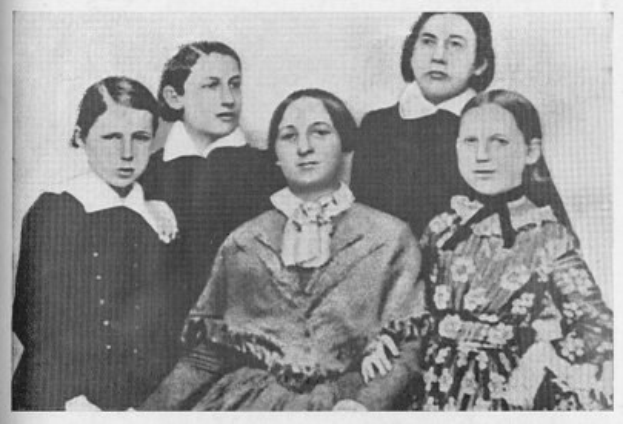 Schwarzes und weißes Foto einer Gruppe von Frauen aus der Frauenwahlrechtsbewegung, mit einer Frau in der Mitte sitzend.