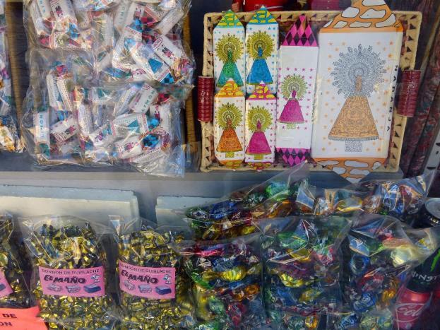 Vitrine im Geschäft gefüllt mit verschiedenen Arten von Süßigkeiten, einschließlich Schokoladenpackungen und Flaschen.