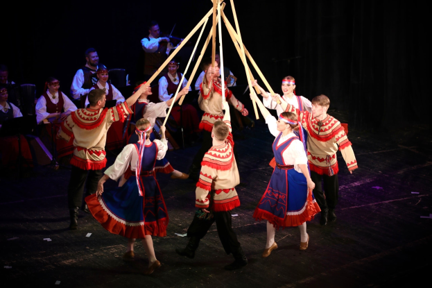 Plakat für das Aphrodite-Festival in Athen, Griechenland, das Menschen vor einem Gebäude mit einem Blumenstrauß im Vordergrund und Text zeigt, der das Ereignis beschreibt.