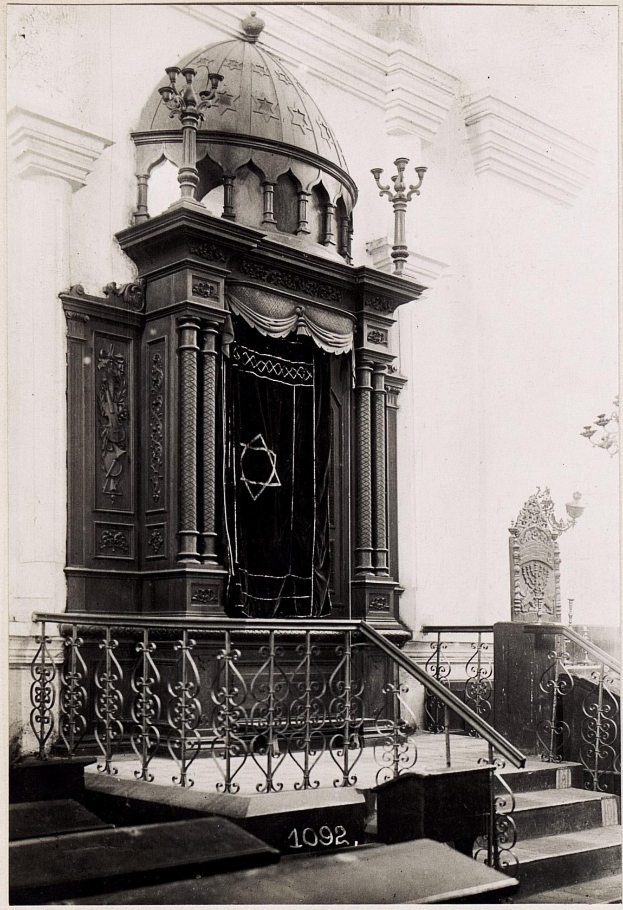 Schwarzes und weißes Foto einer jüdischen Synagoge in New York City mit Treppe, Geländern, Säulen, einer Tür und einer Wand.