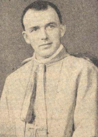 Ein Schwarz-Weiß-Foto eines Mannes in Priesterkleidung, der mutmaßlich der erste Bischof der römisch-katholischen Kirche ist, trägt eine weiße Robe mit schwarzem Kragen und Manschetten, eine schwarze Mütze mit einer weißen Feder, die Hände sind gefaltet und er hat einen ernsten Gesichtsausdruck.