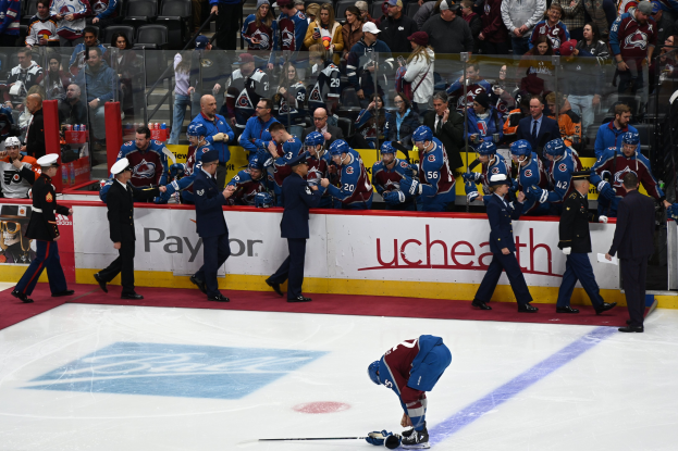 Eishockeyspieler auf dem Eis umgeben von Zuschauern und Teammitgliedern bei einem Spiel der Colorado Avalanche gegen die San Jose Sharks in der NHL am 24. März 2015.