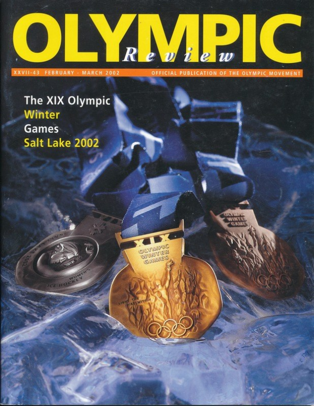 Buchumschlag mit der Aufschrift "Olympische Revue Magazine" und mehreren Medaillen in verschiedenen Größen und Farben sowie fetter Schrift.