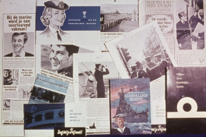 Zeitungen auf einem Tisch mit Bildern eines lachenden Mannes und einer ernsten Frau, beide mit kurzem dunklen Haar und legerer Kleidung.