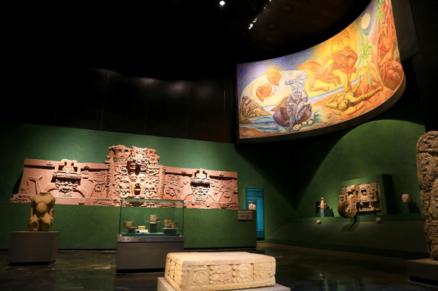 Ausstellung verschiedener Artefakte im Mexiko-Stadt-Museum der Anthropologie, darunter Skulpturen, Tischgegenstände, eine Texttafel, eine Wandmalerei und Deckenbeleuchtung.