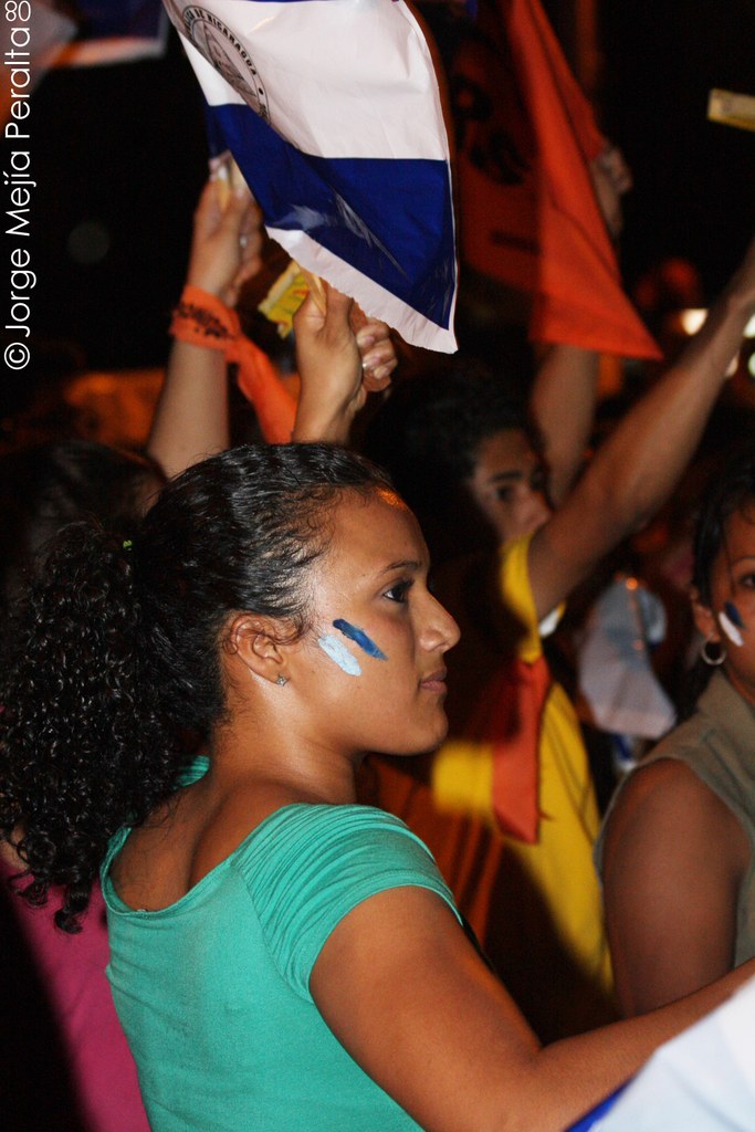 Frauen in grünen T-Shirts bei einer Demonstration, die eine weiße Hülle in der Hand halten.