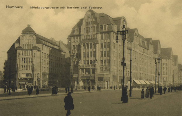 Altes Schwarz-Weiß-Foto von Fußgängern, die eine Straße in Hamburg, Deutschland, entlanggehen, gesäumt von Gebäuden, Straßenlaternen, Lampen und Fahrzeugen unter einem bewölkten Himmel, mit Text oben.