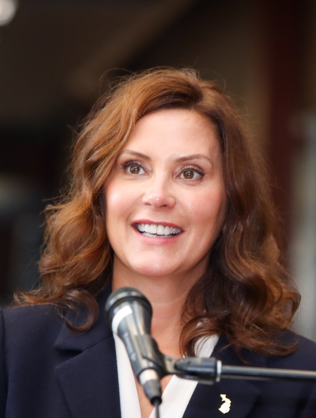 Headshot von Michele Bachmann in einem Anzug und Krawatte, die in ein Mikrofon spricht, mit einem unscharfen Hintergrund.