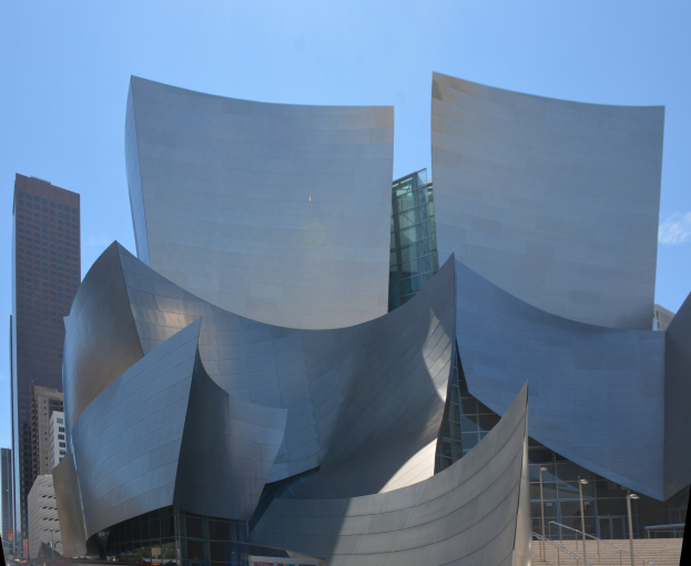 Modernes Konzertgebäude mit Glaswänden und Treppen mit Geländern, die zum Eingang führen, umgeben von Menschen, anderen Gebäuden und einem klaren blauen Himmel in Los Angeles.