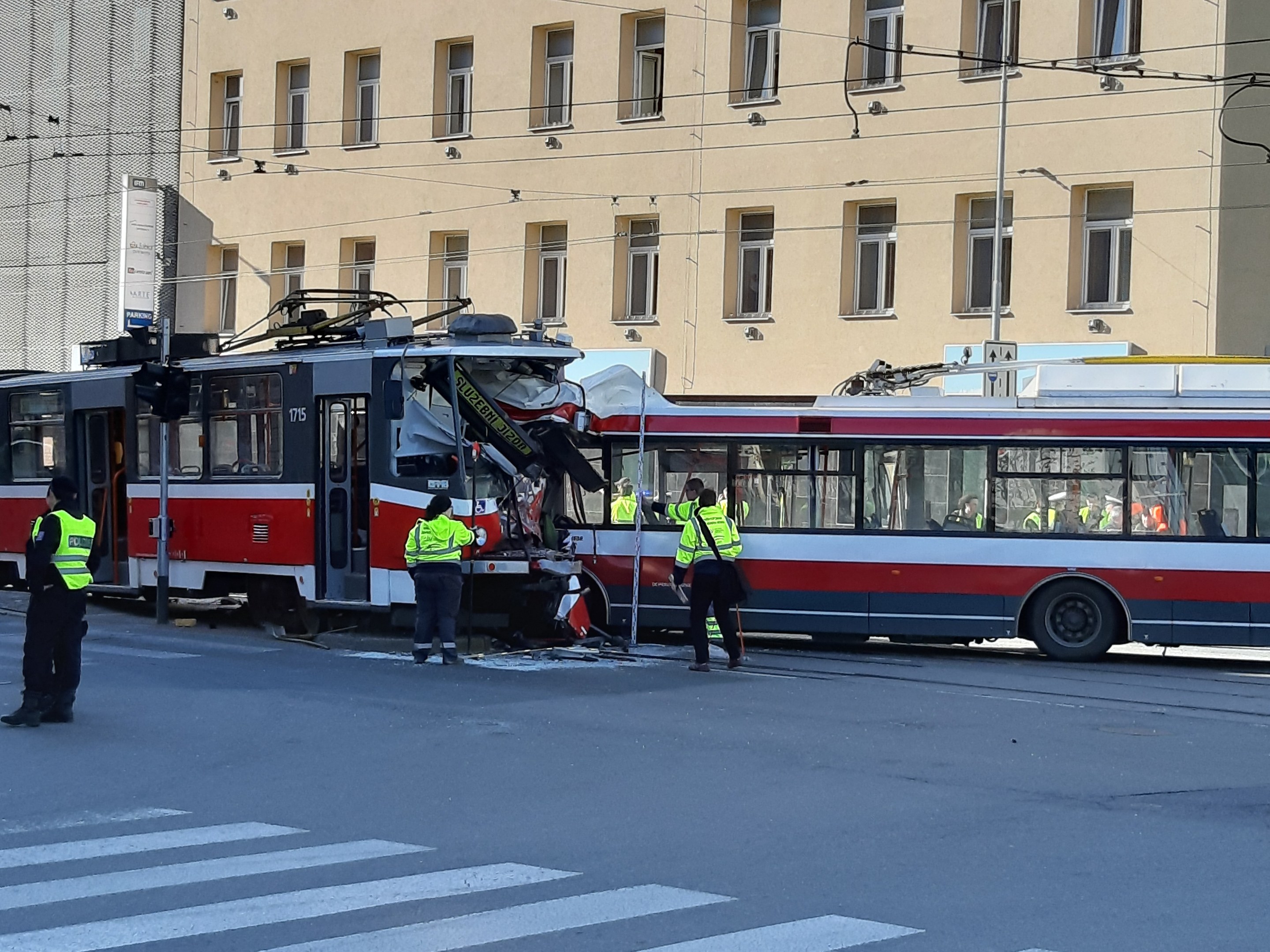 Rote und weiße Straßenbahn krachte auf der Straße mit Menschen in der Nähe und einem Gebäude im Hintergrund.