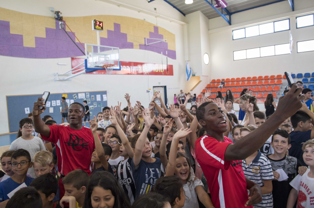 Kinder vor einem Basketballfeld mit Mobiltelefonen während eines Basketballcamps